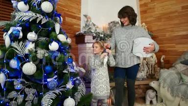 母亲和女儿正在准备新年假期，一家人装饰圣诞树，一家人在家中幸福快乐