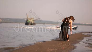 女孩在海边捡贝壳和鹅卵石