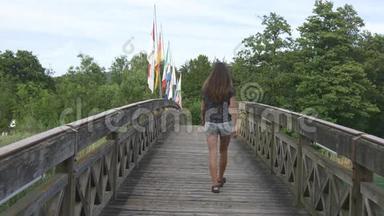女人带着旗子走过木桥
