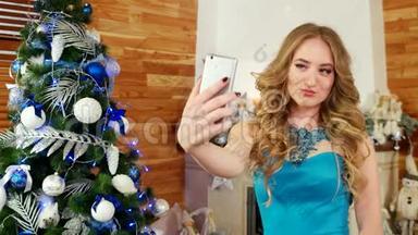 新年照片在<strong>手机</strong>上，女孩自拍，<strong>节</strong>日聚会在圣诞树上美丽的女孩使用<strong>手机</strong>