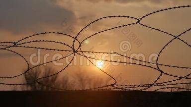 铁丝网监狱围栏。 危险的阳光透过铁丝网穿透罪犯的安全