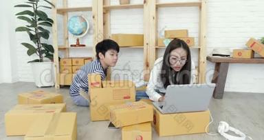 年轻的亚洲妇女，带着一个男孩在泰国工作，并在泰国邮政信箱中打包