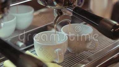 旋转，近距离观看一台银色<strong>咖啡机</strong>，在两个白色杯子中倒入热的、新鲜的<strong>咖啡</strong>。 一台浓缩<strong>咖啡机</strong>