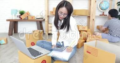 年轻的亚洲妇女，带着一个男孩在泰国工作，并在泰国邮政信箱中打包