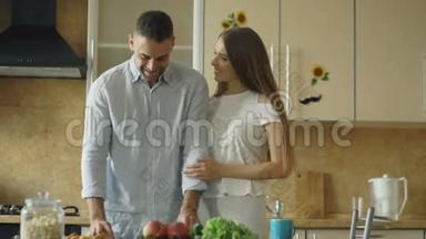 快乐的年轻夫妇在厨房。 英俊的男人一大早就<strong>会见</strong>面喂他的女朋友