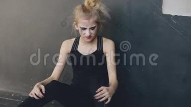 年轻的少女舞者在失去演员后，在室内的舞蹈室里坐在地板上，非常愤怒和痛苦