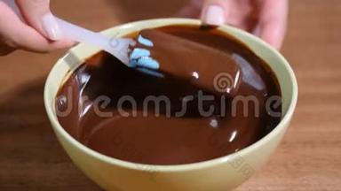 手搅拌巧克力奶油在搅拌碗。