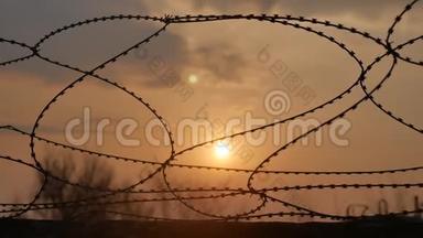 铁丝网监狱围栏。 危险边界的阳光透过铁丝网穿透罪犯的安全