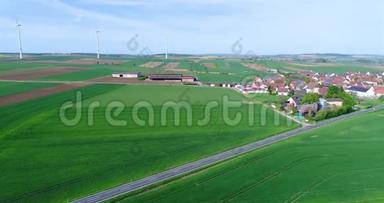 在现代欧洲的一个小村庄附近飞行，在风力发电机附近飞行，在风力发电机的背景下飞行