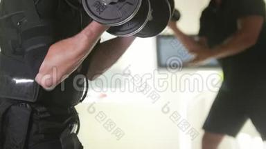 <strong>EMS</strong>训练-肌肉健身教练与身穿EM服的运动员合作-工作手臂