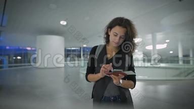 一位年轻漂亮的女士正在旅行前用她的手机检查新手机