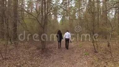 年轻夫妇在森林里<strong>散步</strong>，<strong>手牵手</strong>