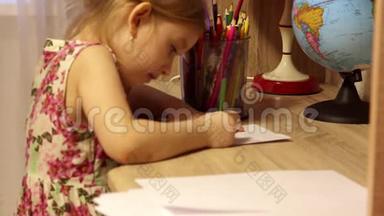 漂亮的小女孩在他的房间里用铅笔在纸上画画。
