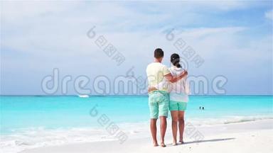 暑假期间在白色海滩上的年轻夫妇。 快乐的恋人享受他们的蜜月。 <strong>流动视频</strong>。