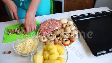 一个女人在切割板上切了新鲜的<strong>香瓜</strong>。 桌子旁边有极好的土豆、烤盘、多汁的切碎机和切碎机