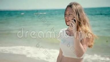 美丽的年轻女子穿着比基尼在<strong>海边玩</strong>智能手机。 阳光明媚的夏天在<strong>海边</strong>