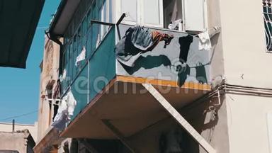 在城市阳光下的绳索上晾干的东西。 洗过的男人在阳台上的绳子上穿着干燥的衣服。 <strong>一切</strong>都在不断发展