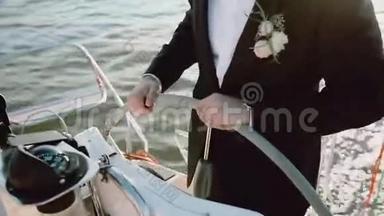 在游艇上，新郎穿着婚纱站在方向盘后面的特写镜头。 在海上驾驶这艘船的人。