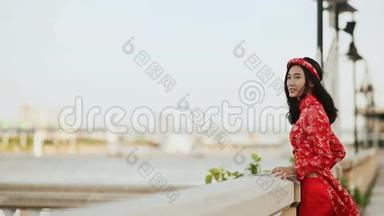 越南女孩穿着全国红裙傲黛在<strong>海边</strong>摆姿势，微笑着为相机<strong>拍照</strong>