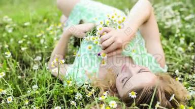 女孩依靠大自然。 美丽的女孩躺在田野上。