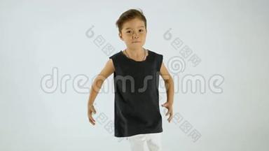 穿着黑色T恤跳舞，玩得开心的小男孩，在白色上孤独