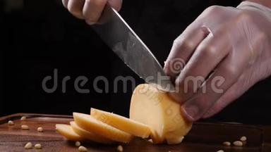厨师戴手套用刀切奶酪。 餐厅。 服务对象