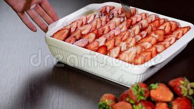 女人用刀切草莓提拉米苏。草莓提拉米苏甜点。