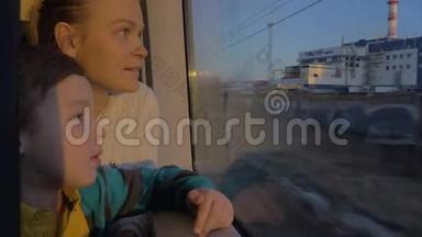 在圣彼得堡，坐火车的俄罗斯骑着一位年轻的母亲和一个儿子，望着窗外