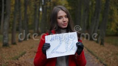 美丽的白种人女人，穿着<strong>红色</strong>外套，在秋天的森林里，用纸出售<strong>标语</strong>牌