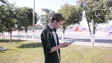 年轻的嬉皮士在城市公园里用平板电脑玩口袋妖怪<strong>围棋</strong>。