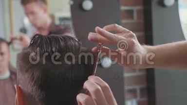 理发店里理发师的特写用剪刀缓慢地<strong>剪头发</strong>。