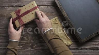 男人把礼品盒一个一个<strong>放在</strong>木制<strong>桌面上</strong>