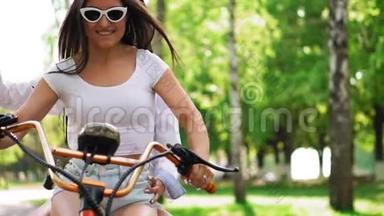 在公园里，两个头发松松的年轻和黑发朋友穿着短牛仔短裤，骑着<strong>电动</strong>摩托车骑着一辆<strong>电动</strong>摩托车