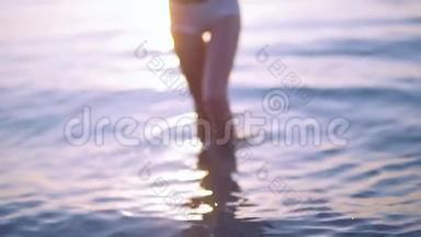 漂亮的腿。 女孩从海里出来。 慢动作。 注意力不集中。 好的背景