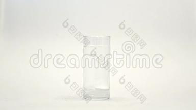 白色背景下玻璃水中泡腾白色片剂。 泡沫片