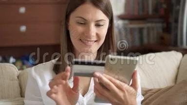 穿着白色衬衫的<strong>女人</strong>坐在客厅的沙发上，用智能<strong>手机刷</strong>卡上网