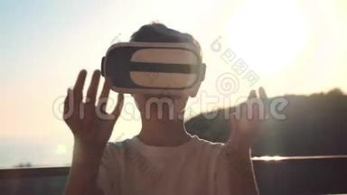 日落时快乐的男孩，戴着<strong>虚拟现实</strong>眼镜，玩电子游戏，快乐的<strong>微笑</strong>，看着VR眼镜和<strong>虚拟现实</strong>眼镜