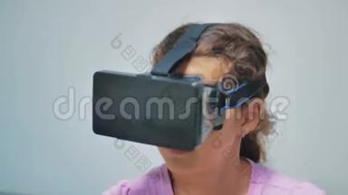 快乐的小<strong>女孩使用</strong>3d护目镜虚拟现实耳机。 带着VR设备的惊喜女人。 快乐的微笑<strong>女孩</strong>