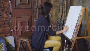 年轻的女画家用铅笔在画架画布上<strong>画画</strong>，准备<strong>画画</strong>