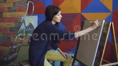 年轻的女画家用铅笔在画架画布上<strong>画画</strong>，准备<strong>画画</strong>