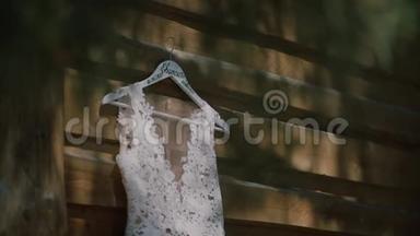 婚纱挂在户外。白色婚纱挂在木屋上，风吹着裙子。