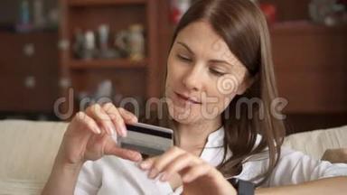 穿着白色衬衫的女人坐在客厅的沙发上，用智能手机刷卡上网