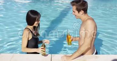 一对英俊的年轻夫妇在游泳池里狂欢