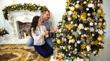 一对情侣一起为即将到来的节日做准备，在喜庆的圣诞树和圣诞树的背景下，拥抱在明亮的房间里