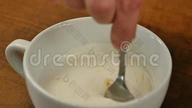 咖啡师在浓黑咖啡中加入椰奶，用勺子摇一摇