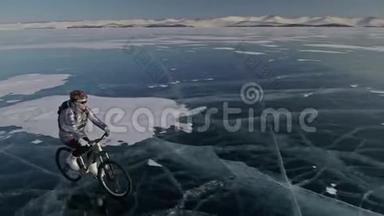 女人在冰上骑自行车。 女孩穿着银色羽绒服，自行车背包和头盔。 射击