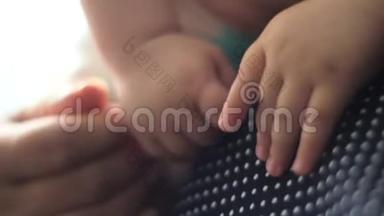 妈妈把婴儿抱在怀里婴儿手特写。
