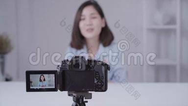 快乐微笑的亚洲女人或美女博主用画笔和相机<strong>录制</strong>视频，并在家挥手。