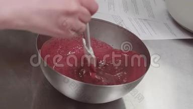 糕点厨师用手搅拌混合碗中的红色浆果<strong>果脯</strong>