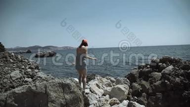 女孩站在海边的粗糙石头上，看着海港那边的<strong>高楼大厦</strong>建设